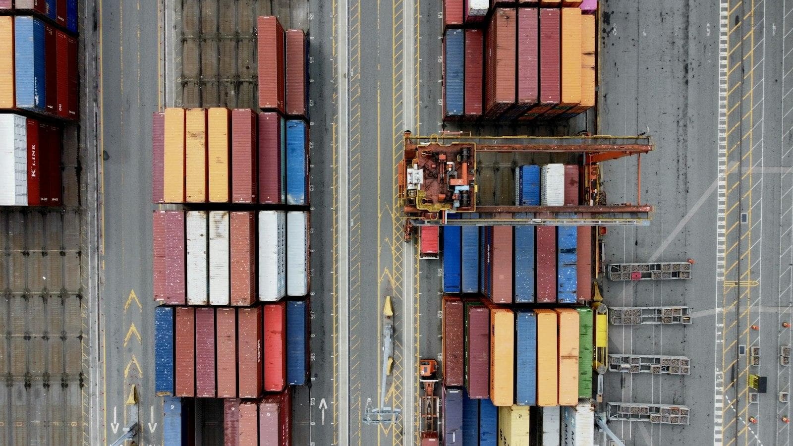 Shipping containers stacked at a port, seen from above